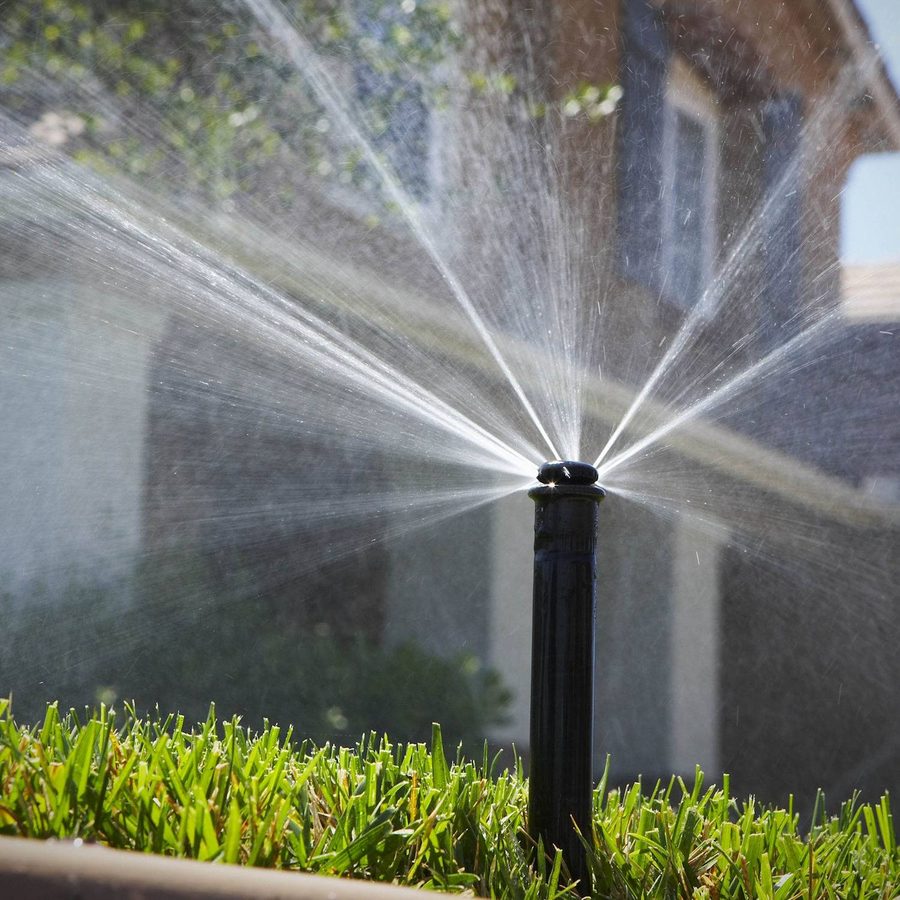 Pop-up sprinkler watering a garden lawn